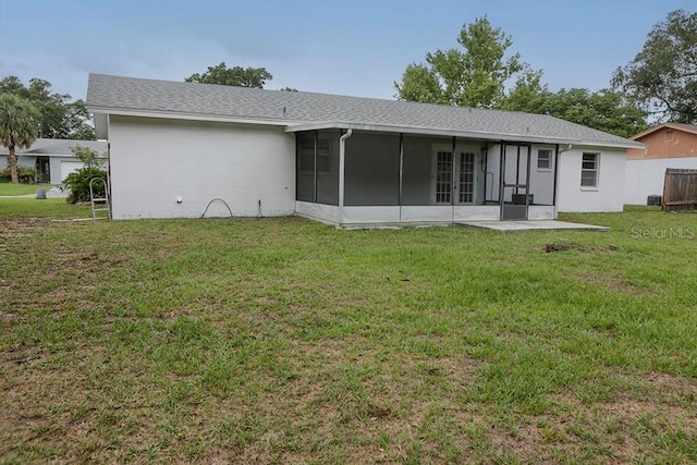 back of property with a sunroom, french doors, and a yard