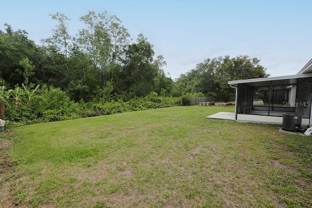 view of yard featuring central AC and a sunroom