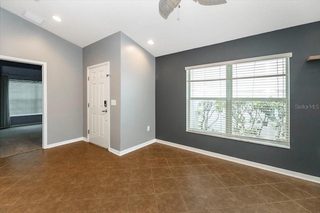 12654 Belcroft Dr, Riverview, FL 33579 - empty room featuring plenty of natural light, dark tile patterned floors, a ceiling fan, vaulted ceiling, and baseboards