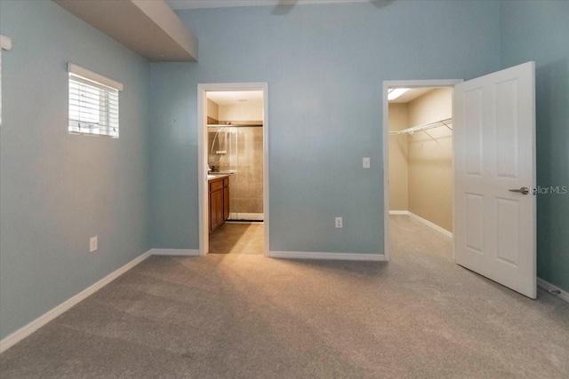 12654 Belcroft Dr, Riverview, FL 33579 - unfurnished bedroom featuring a walk in closet, light carpet, baseboards, connected bathroom, and a closet