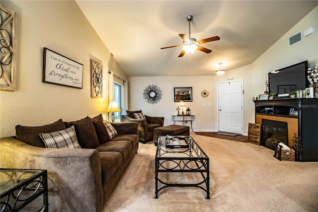 living room featuring a ceiling fan and a glass covered fireplace