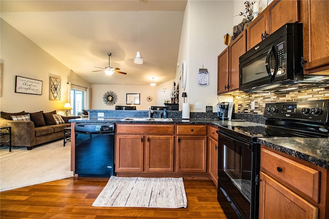kitchen with black appliances, a peninsula, open floor plan, ceiling fan, and dark wood finished floors