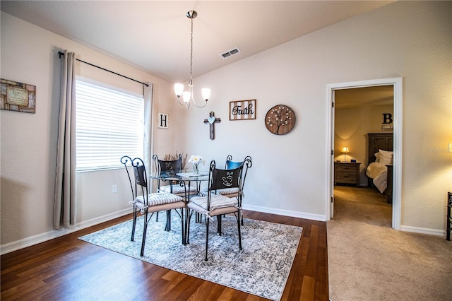 dining space featuring vaulted ceiling, a chandelier, baseboards, and dark wood-style floors