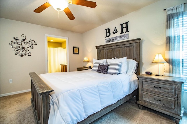 carpeted bedroom with baseboards, connected bathroom, and ceiling fan