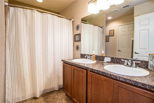 bathroom with double vanity and tile patterned flooring