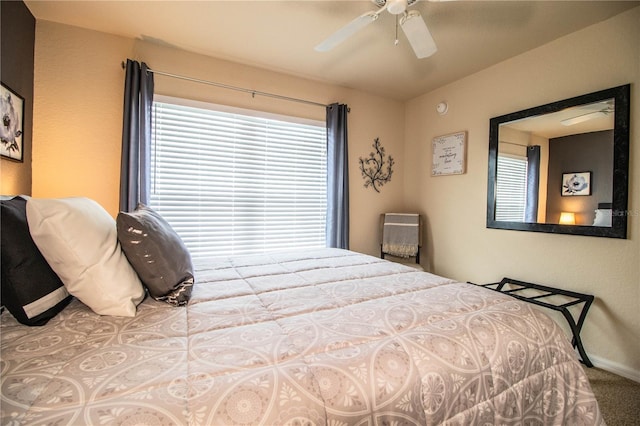 carpeted bedroom with a ceiling fan and baseboards