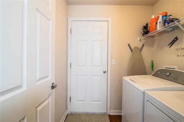 clothes washing area featuring separate washer and dryer and baseboards