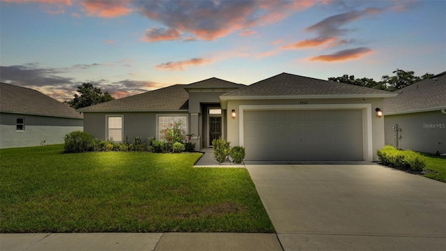 4582 Penkert Pl, Lakeland, FL 33811 - view of front facade featuring stucco siding, concrete driveway, a garage, a front lawn, and roof with shingles