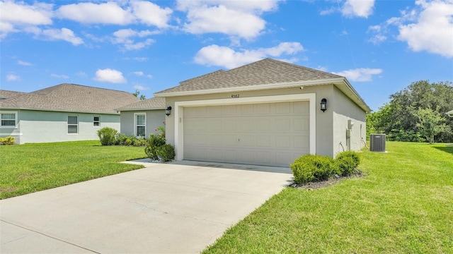 4582 Penkert Pl, Lakeland, FL 33811 - view of front of property featuring stucco siding, central air condition unit, driveway, a garage, and a front yard