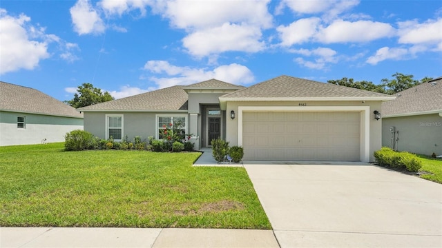 4582 Penkert Pl, Lakeland, FL 33811 - view of front of home featuring stucco siding, a garage, a front yard, driveway, and roof with shingles