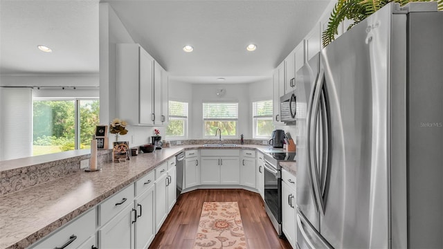 4582 Penkert Pl, Lakeland, FL 33811 - kitchen with stainless steel appliances, white cabinetry, a sink, recessed lighting, and dark wood-style flooring