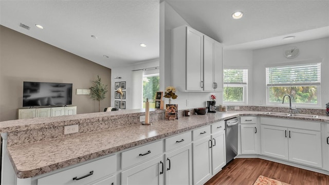 4582 Penkert Pl, Lakeland, FL 33811 - kitchen featuring a sink, a peninsula, lofted ceiling, dishwasher, and wood finished floors