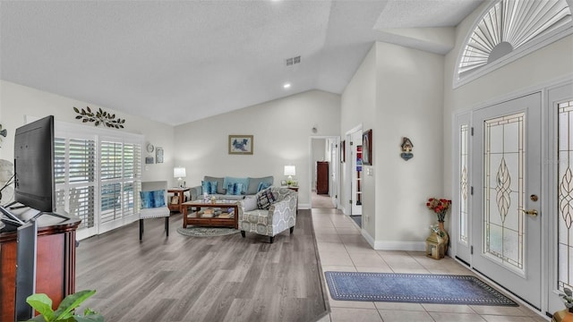 2912 Aston Ave, Plant City, FL 33566 - foyer entrance featuring plenty of natural light, high vaulted ceiling, baseboards, a textured ceiling, and light wood-style floors