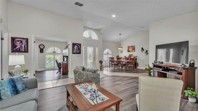 2912 Aston Ave, Plant City, FL 33566 - living room featuring healthy amount of natural light, high vaulted ceiling, a textured ceiling, baseboards, and wood finished floors