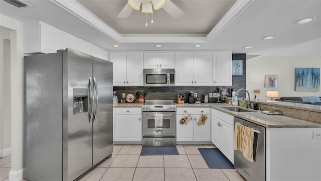 2912 Aston Ave, Plant City, FL 33566 - kitchen with stainless steel appliances, a sink, a peninsula, tasteful backsplash, and a tray ceiling