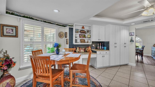 2912 Aston Ave, Plant City, FL 33566 - dining room with a tray ceiling, a ceiling fan, light tile patterned floors, and baseboards