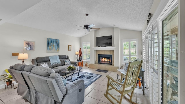 2912 Aston Ave, Plant City, FL 33566 - living area featuring light tile patterned floors, lofted ceiling, a tiled fireplace, a ceiling fan, and a textured ceiling