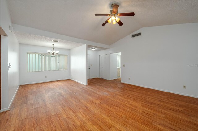 409 San Jose Dr, Winter Haven, FL 33884 - empty room featuring a chandelier, ceiling fan, light wood-style flooring, baseboards, and vaulted ceiling