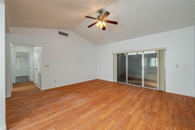 409 San Jose Dr, Winter Haven, FL 33884 - empty room with ceiling fan, lofted ceiling, light wood finished floors, baseboards, and a textured ceiling