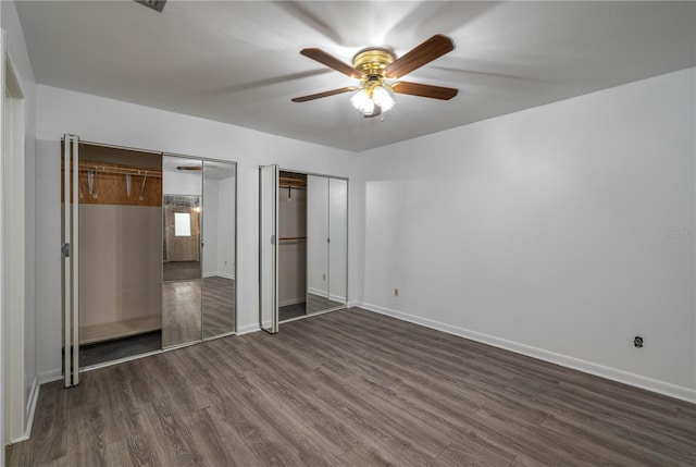 409 San Jose Dr, Winter Haven, FL 33884 - unfurnished bedroom featuring two closets, dark wood-type flooring, and baseboards