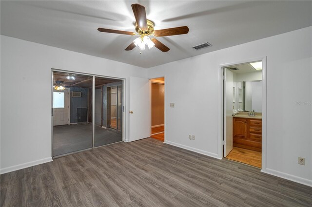 409 San Jose Dr, Winter Haven, FL 33884 - unfurnished bedroom with wood finished floors, baseboards, a closet, a sink, and ceiling fan