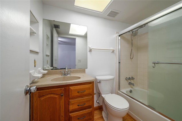 409 San Jose Dr, Winter Haven, FL 33884 - bathroom with toilet, vanity, and shower / bath combination with glass door