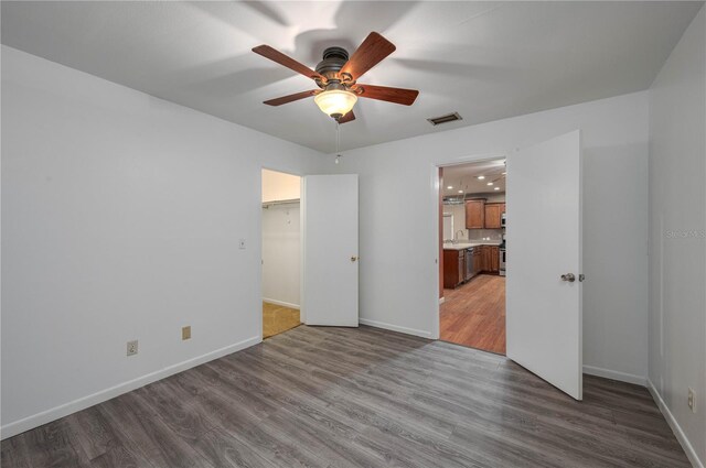 409 San Jose Dr, Winter Haven, FL 33884 - unfurnished bedroom featuring wood finished floors, baseboards, a sink, and ceiling fan