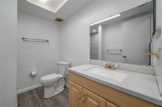 409 San Jose Dr, Winter Haven, FL 33884 - bathroom with wood finished floors, toilet, baseboards, and vanity