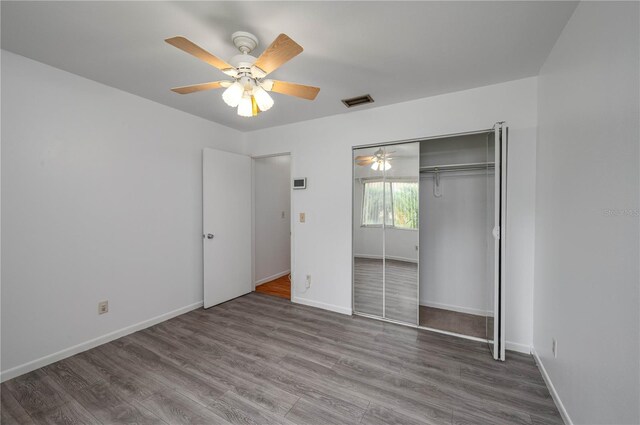 409 San Jose Dr, Winter Haven, FL 33884 - unfurnished bedroom with wood finished floors, baseboards, a closet, and a ceiling fan