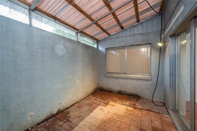409 San Jose Dr, Winter Haven, FL 33884 - empty room featuring brick floors, beamed ceiling, and high vaulted ceiling