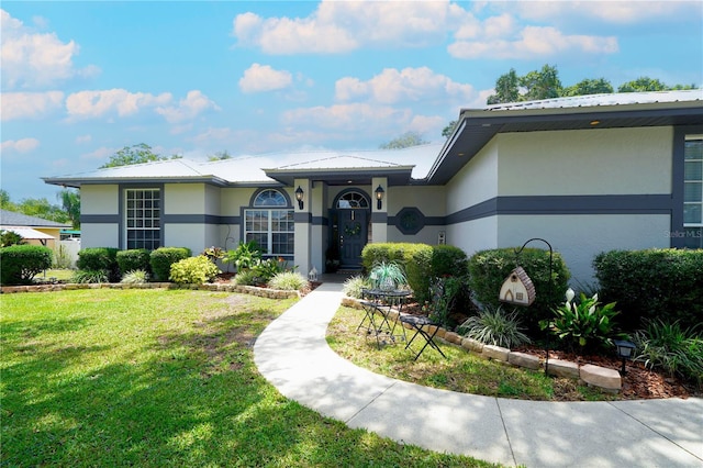8760 Plantation Ridge Blvd, Lakeland, FL 33809 - view of front facade with stucco siding, a front lawn, and metal roof