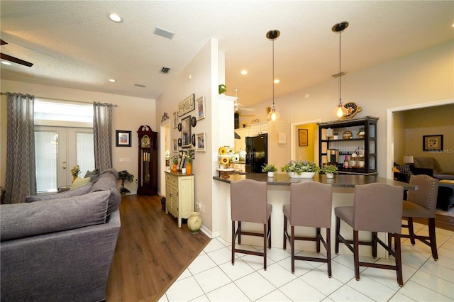 8760 Plantation Ridge Blvd, Lakeland, FL 33809 - kitchen featuring black refrigerator with ice dispenser, open floor plan, a kitchen bar, a peninsula, and dark countertops
