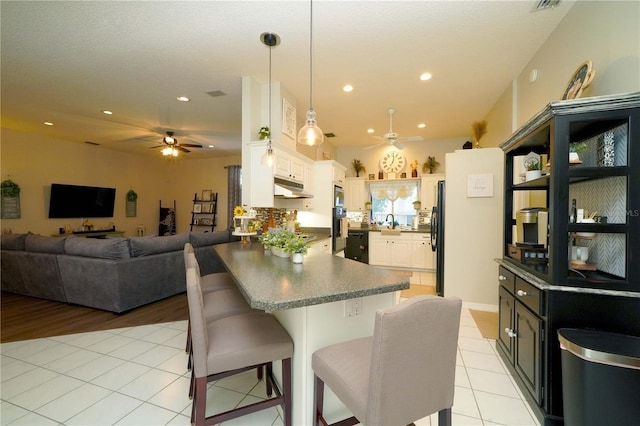 8760 Plantation Ridge Blvd, Lakeland, FL 33809 - kitchen featuring a ceiling fan, under cabinet range hood, a peninsula, open floor plan, and light tile patterned floors