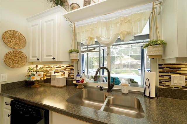 8760 Plantation Ridge Blvd, Lakeland, FL 33809 - kitchen featuring a sink, dark countertops, dishwasher, backsplash, and white cabinetry