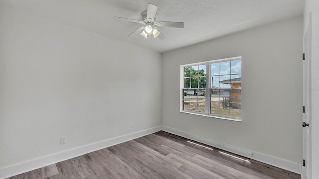725 Ave B SW, Winter Haven, FL 33880 - spare room with wood finished floors, a ceiling fan, and baseboards