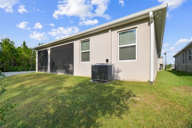 15354 Sweet Springs Bnd, Odessa, FL 33556 - rear view of property with central air condition unit, a lawn, and stucco siding