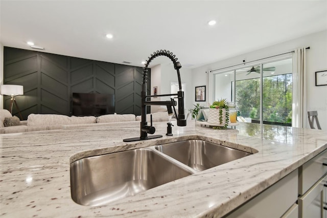 15354 Sweet Springs Bnd, Odessa, FL 33556 - kitchen view of a sink, light stone countertops, recessed lighting, and a decorative wall