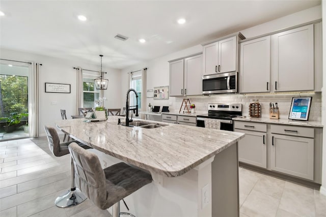 15354 Sweet Springs Bnd, Odessa, FL 33556 - kitchen with stainless steel appliances, a sink, backsplash, recessed lighting, and a kitchen breakfast bar