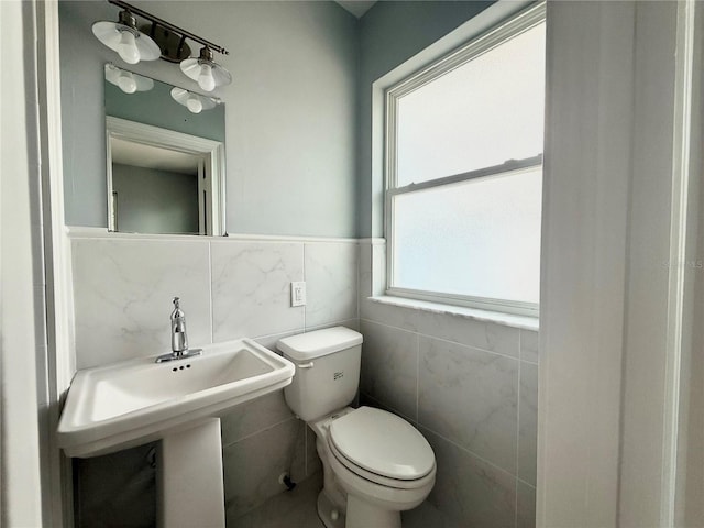 1328 Edgewater Beach Dr, Lakeland, FL 33805 - half bath featuring tile walls, toilet, and wainscoting