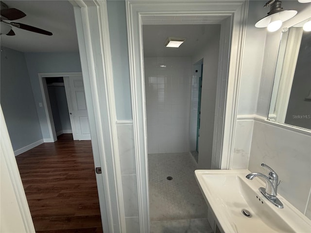 1328 Edgewater Beach Dr, Lakeland, FL 33805 - bathroom with wood finished floors, a sink, a ceiling fan, and tiled shower