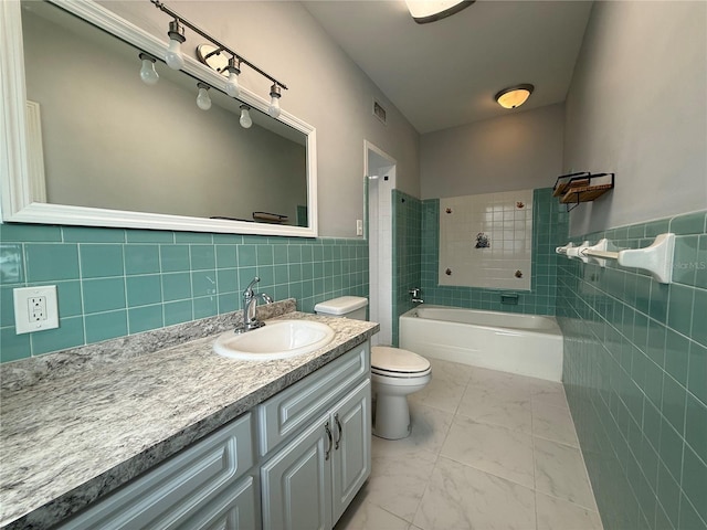 1328 Edgewater Beach Dr, Lakeland, FL 33805 - full bathroom featuring tile walls, marble finish flooring, toilet, vanity, and wainscoting