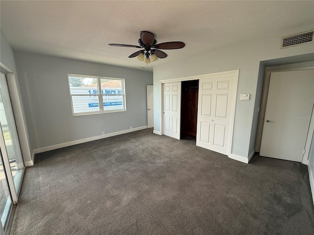 1328 Edgewater Beach Dr, Lakeland, FL 33805 - unfurnished bedroom featuring dark carpet, a closet, baseboards, a ceiling fan, and a textured ceiling