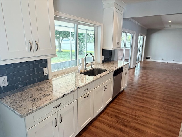1328 Edgewater Beach Dr, Lakeland, FL 33805 - kitchen with stainless steel dishwasher, a sink, dark wood-style flooring, crown molding, and white cabinetry