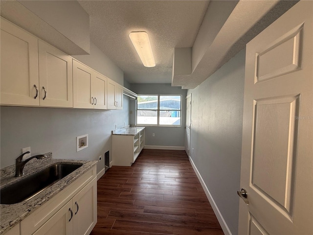 1328 Edgewater Beach Dr, Lakeland, FL 33805 - laundry area with hookup for a washing machine, cabinet space, a textured ceiling, dark wood-style flooring, and baseboards