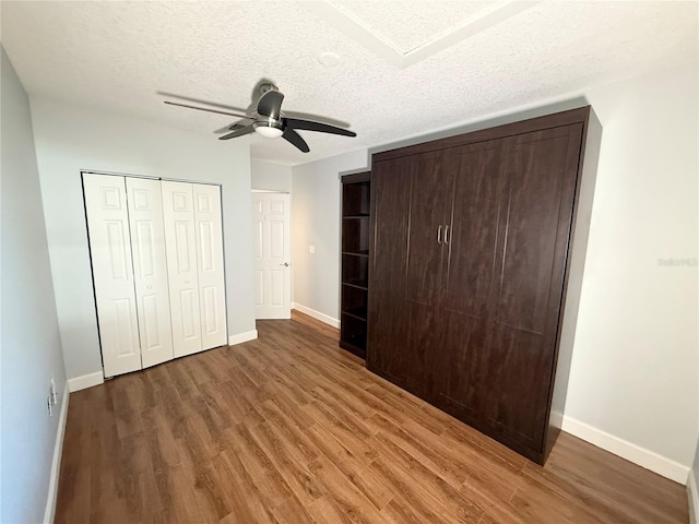 1328 Edgewater Beach Dr, Lakeland, FL 33805 - unfurnished bedroom with wood finished floors, baseboards, a textured ceiling, and ceiling fan