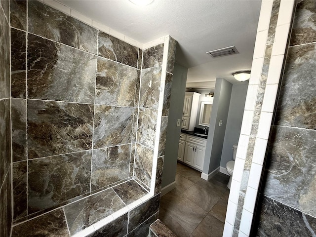1328 Edgewater Beach Dr, Lakeland, FL 33805 - full bathroom with toilet, tiled shower, vanity, tile patterned floors, and a textured ceiling