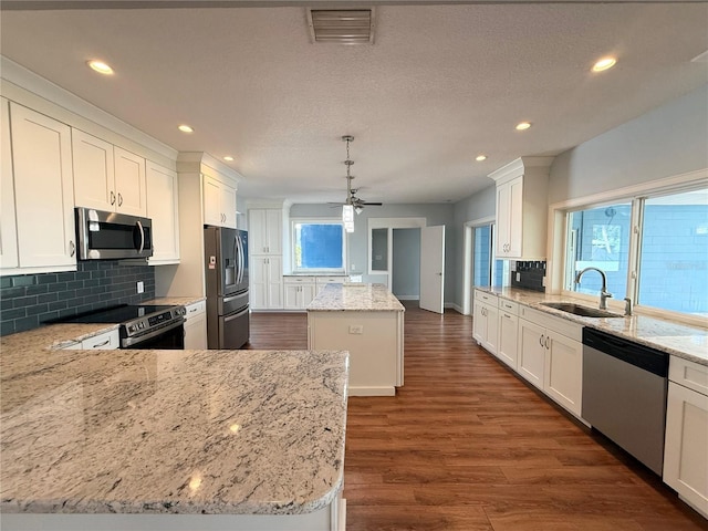 1328 Edgewater Beach Dr, Lakeland, FL 33805 - kitchen with appliances with stainless steel finishes, a sink, a center island, backsplash, and recessed lighting