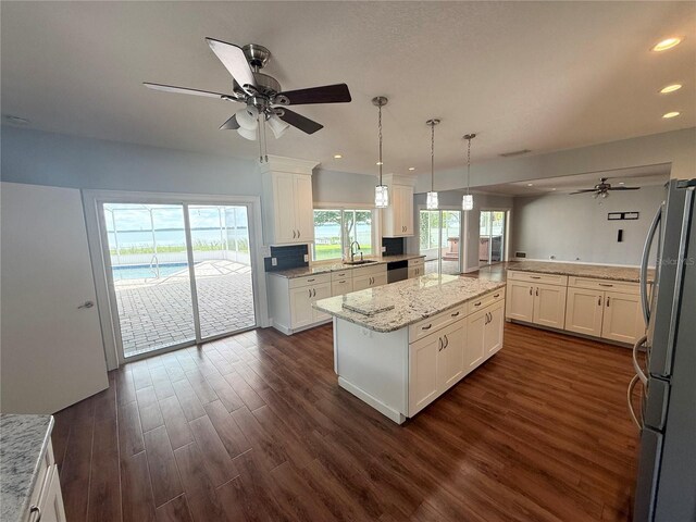 1328 Edgewater Beach Dr, Lakeland, FL 33805 - kitchen with freestanding refrigerator, a ceiling fan, a sink, a center island, and recessed lighting