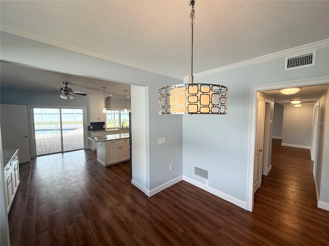 1328 Edgewater Beach Dr, Lakeland, FL 33805 - unfurnished dining area featuring dark wood finished floors, a textured ceiling, baseboards, ornamental molding, and a ceiling fan