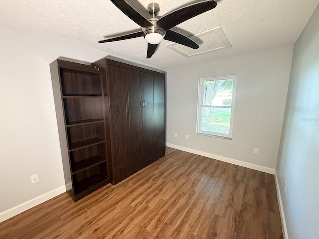 1328 Edgewater Beach Dr, Lakeland, FL 33805 - unfurnished bedroom featuring a textured ceiling, wood finished floors, baseboards, and a ceiling fan